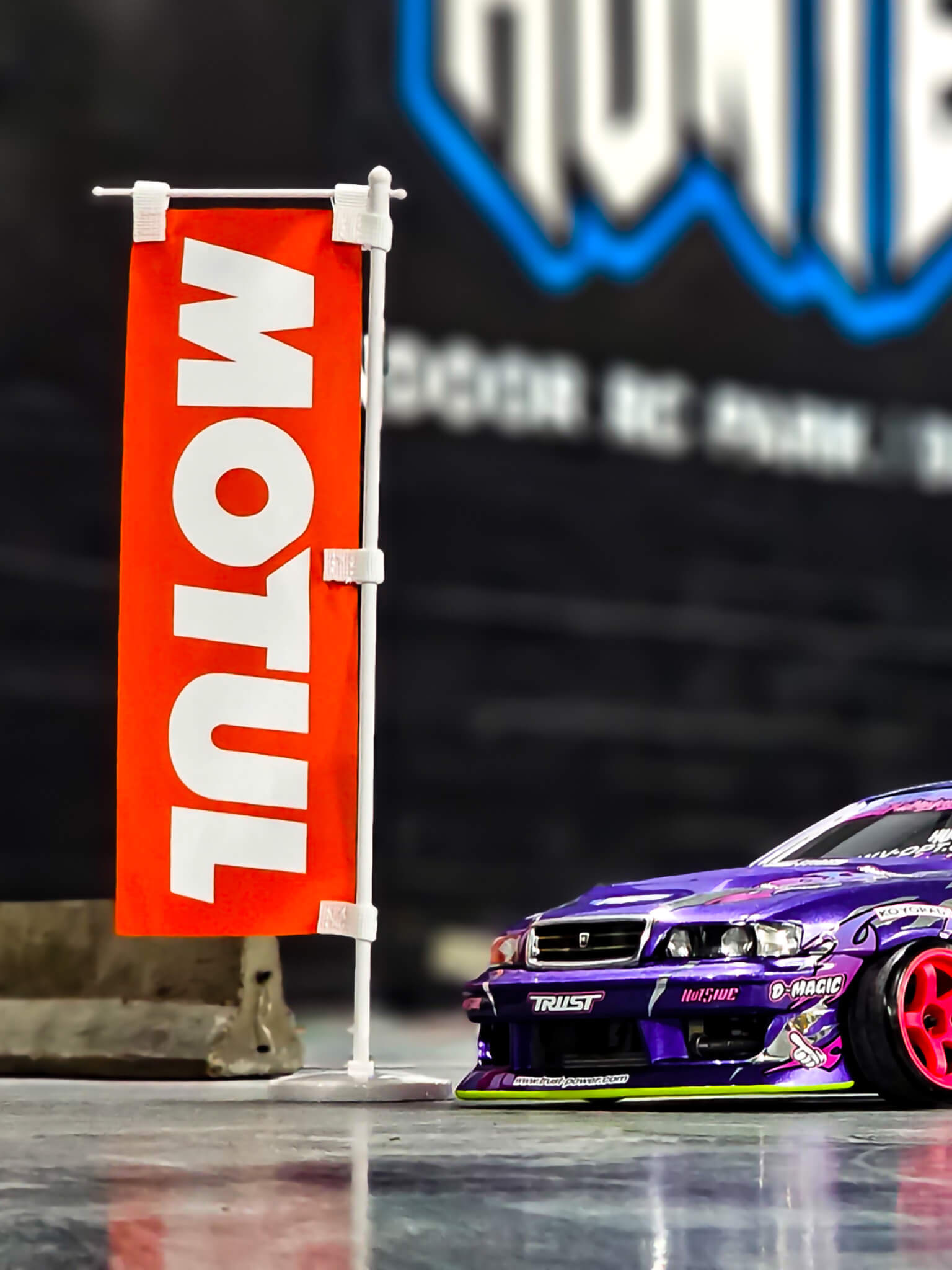 Motul Mini Nobori Flag with Stand posed next to RC Car